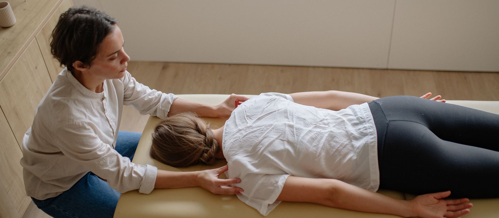 A chiropractor treating a patient on a table, chiropractor web design by Designs by Delia