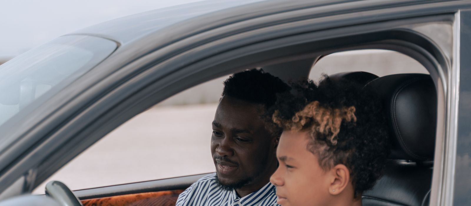 A driving instructor teaching a student behind the wheel, driving school web design by Designs by Delia