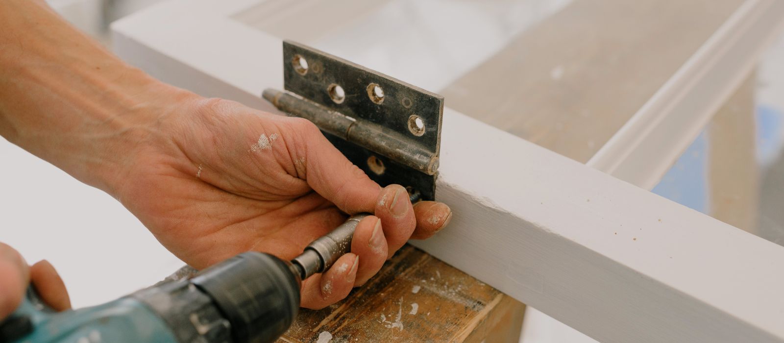 A tradesperson repairing a door in a home, home services web design by Designs by Delia