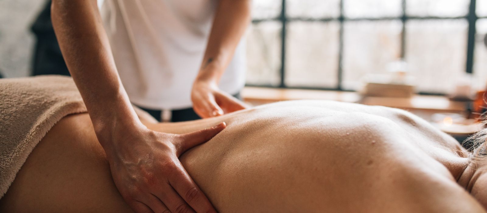 A massage therapist working with a client in a calm treatment room, massage therapist web design by Designs by Delia