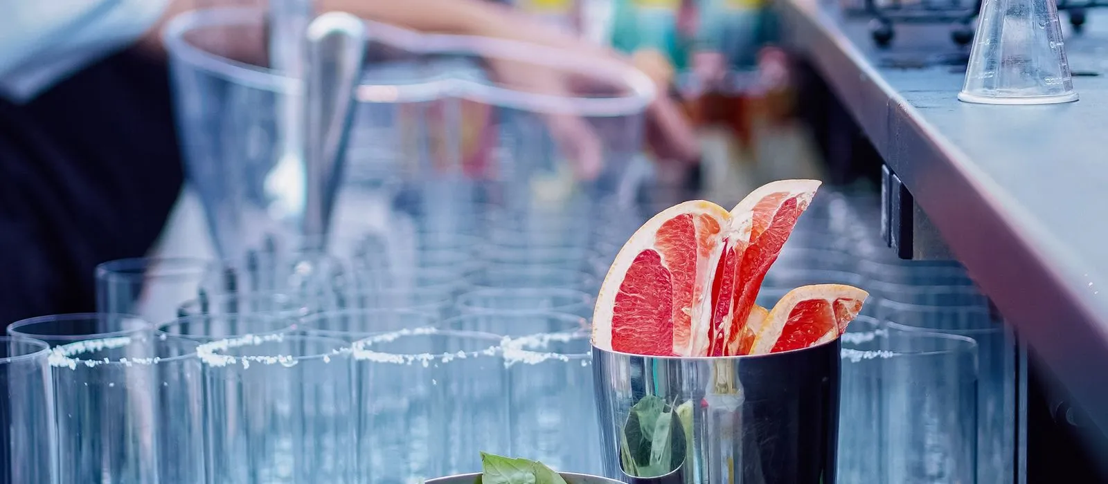 A bartender preparing cocktails at an event bar, mobile bar web design by Designs by Delia