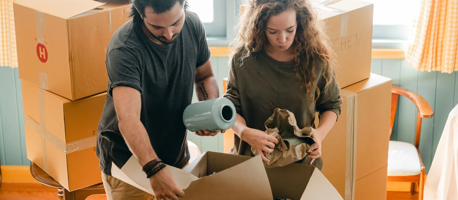 A couple packing moving boxes in a home, moving company web design by Designs by Delia