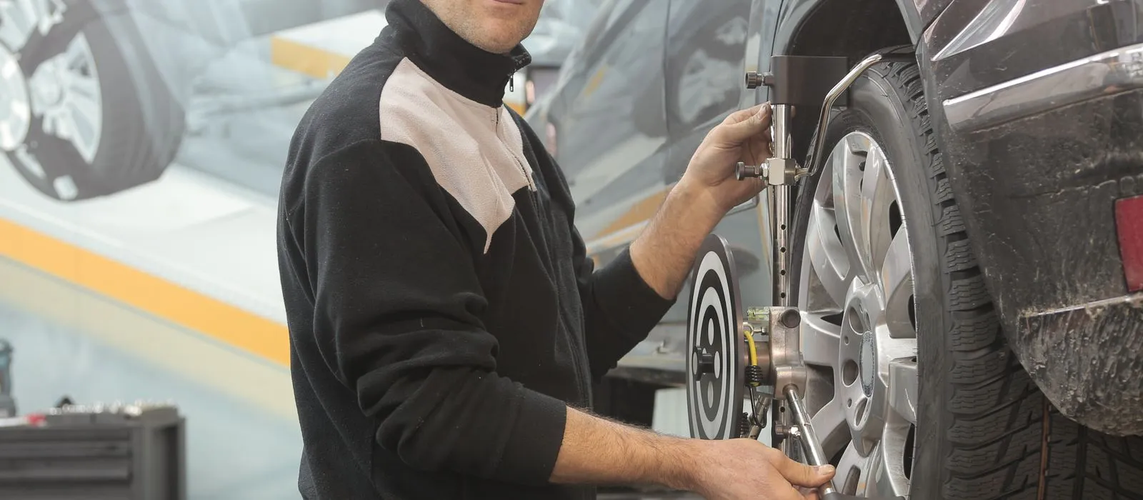 A technician working on a wheel at a tire shop, tire shop web design by Designs by Delia