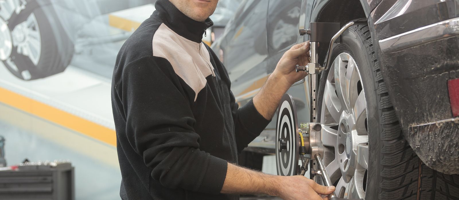 A technician working on a wheel at a tire shop, tire shop web design by Designs by Delia