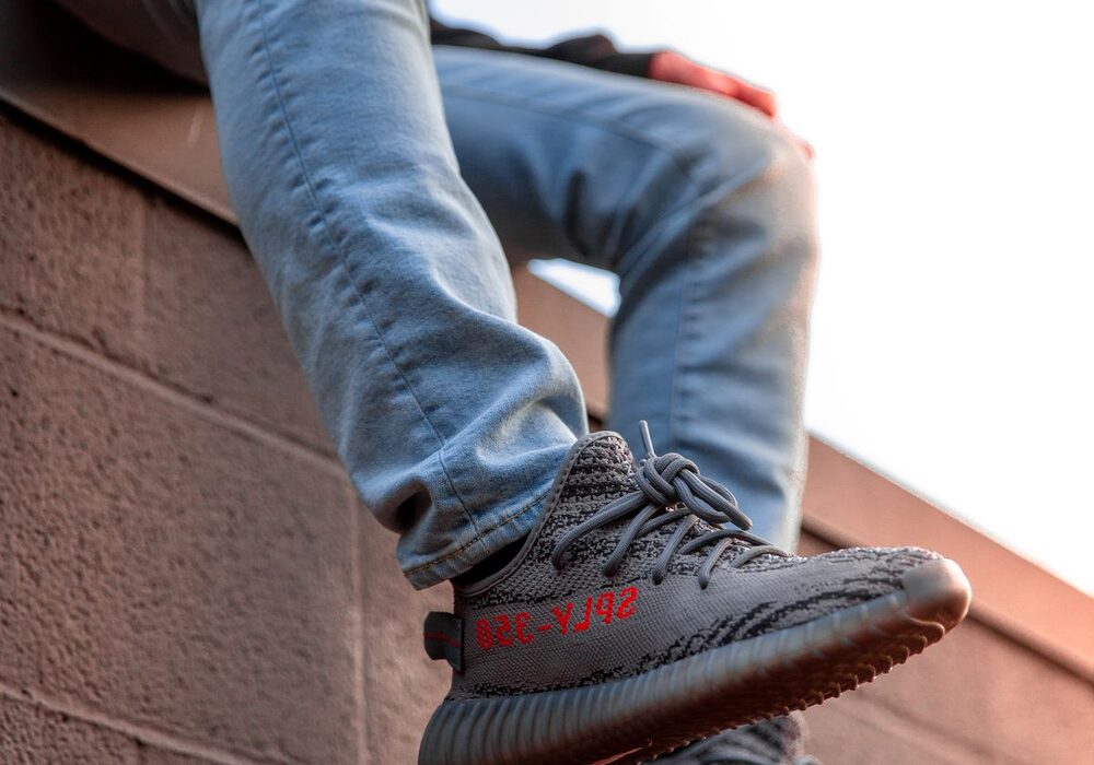 Kid sitting on a wall in bright sneakers