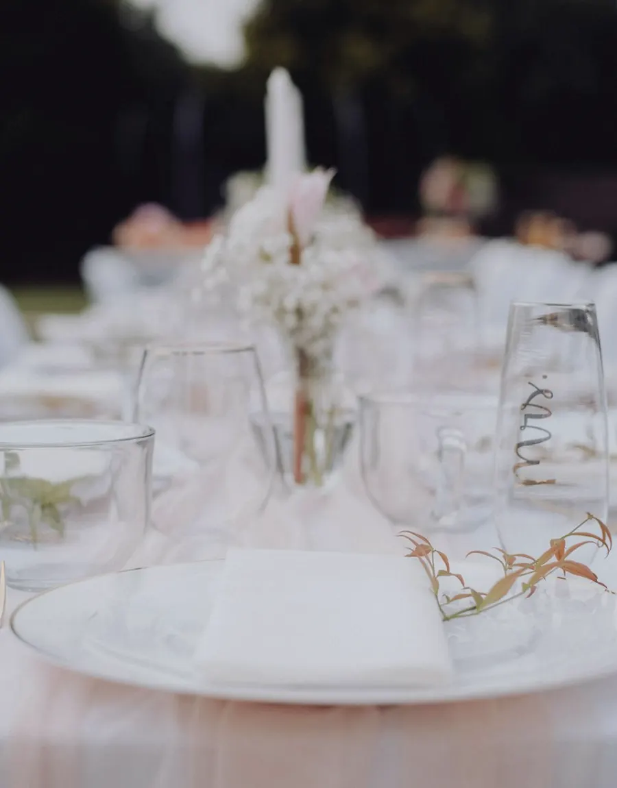 Long table set outdoors in white linen
