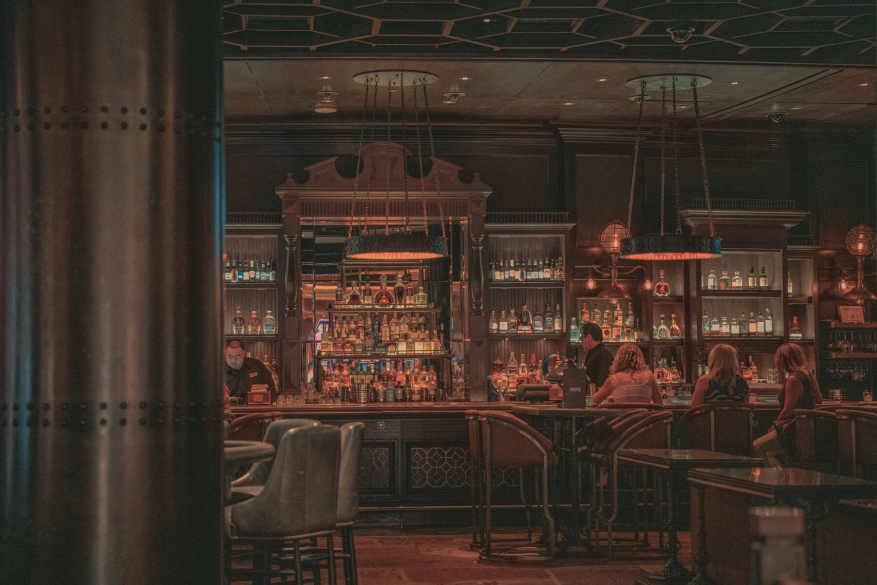 A dark cocktail bar interior lit by low lamps