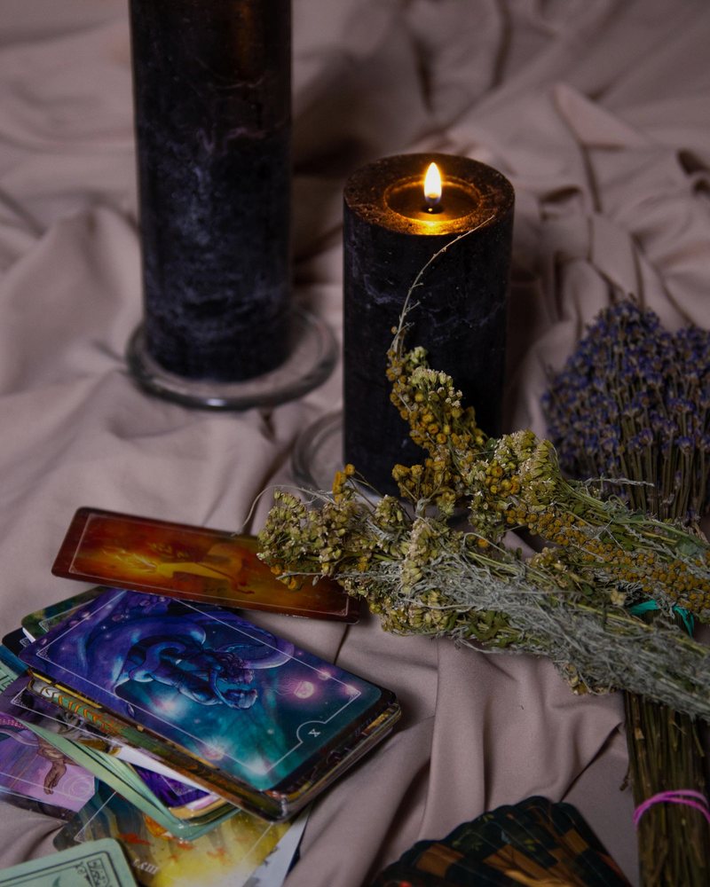 Candles and tarot cards on a dark table