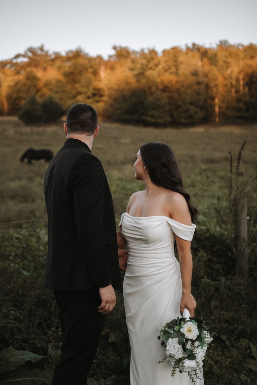 Couple standing in a field at dusk