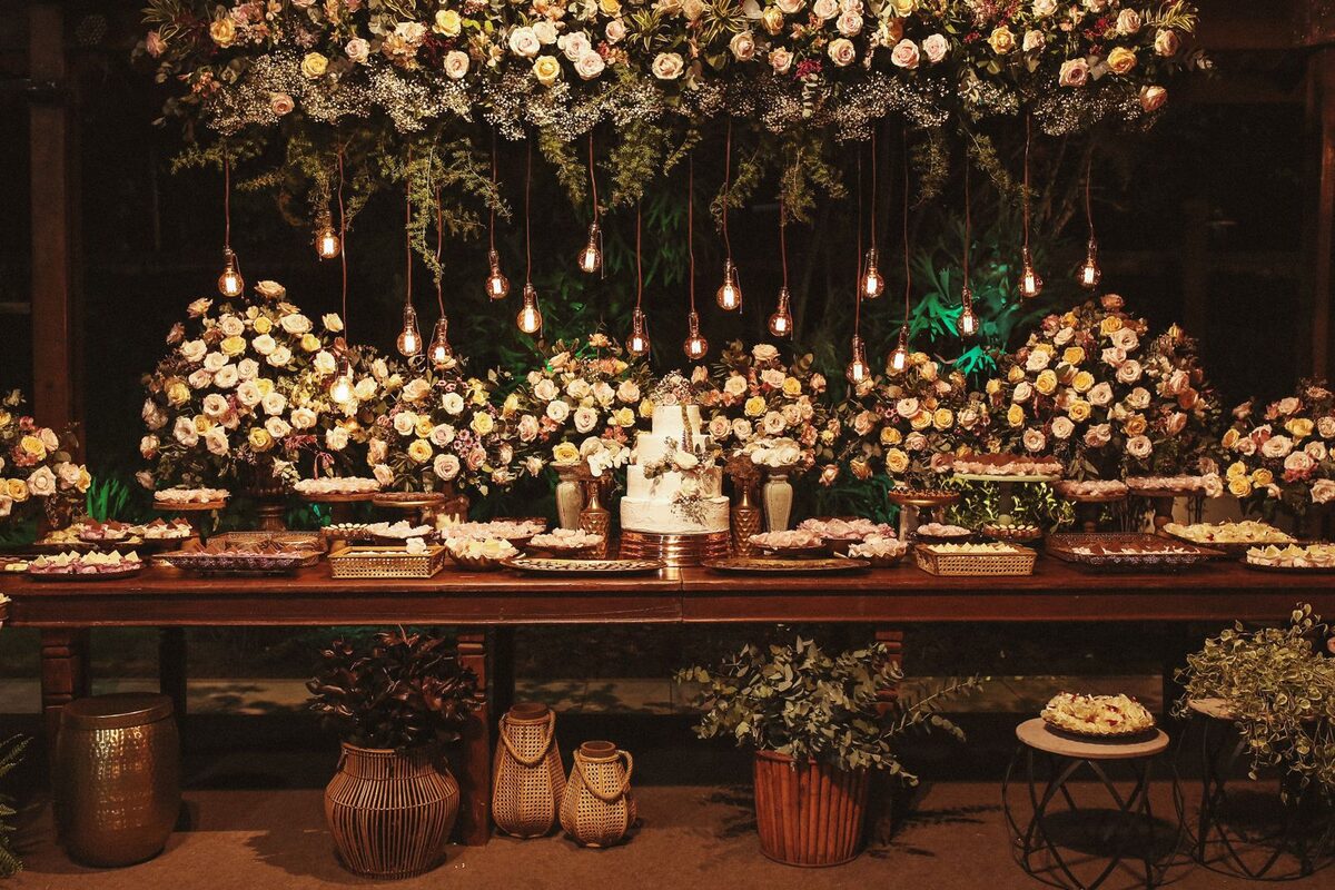 Long table set with flowers under hanging bulbs